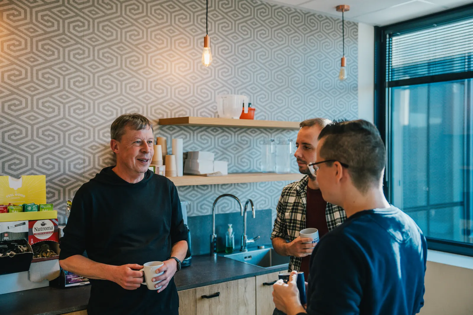 Pebble colleagues chatting over coffee in the office kitchen