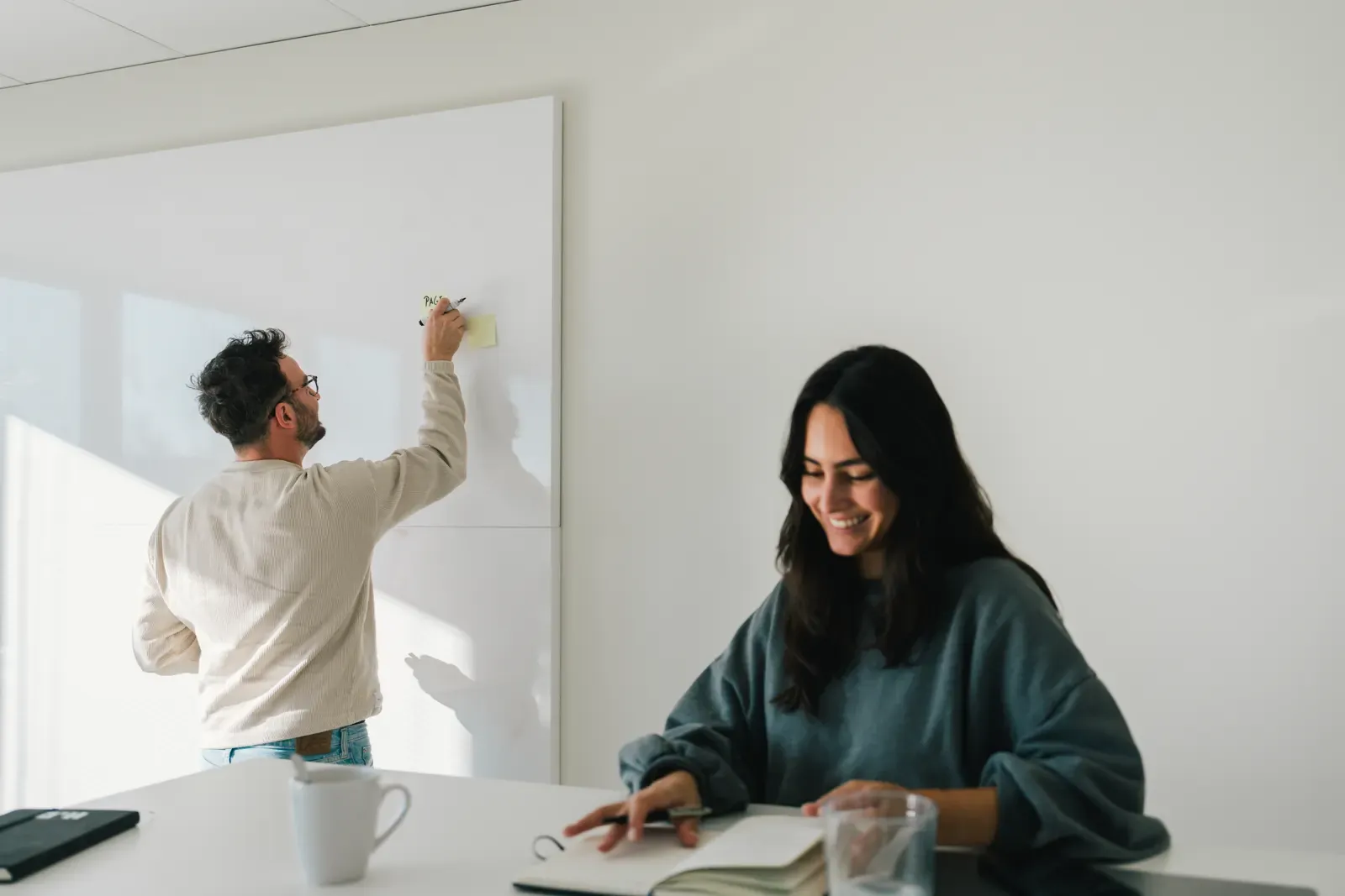 A customer journey being mapped out on a whiteboard while a colleague takes notes
